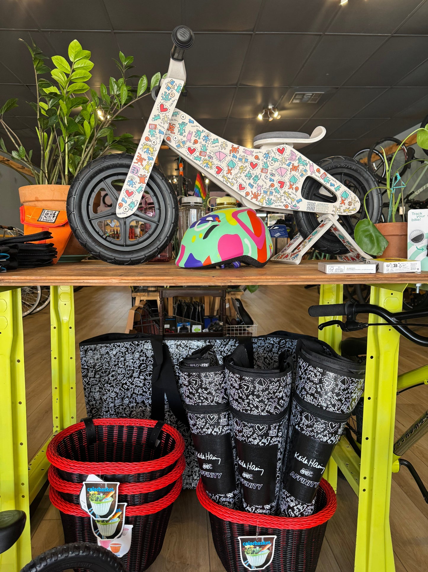 Keith Haring x Affinity push bike and XXL totes displayed in bike shop.
