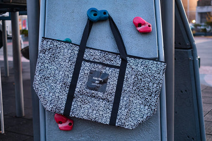 Keith Haring x Affinity XXL Tote Bag hanging from a jungle gym.