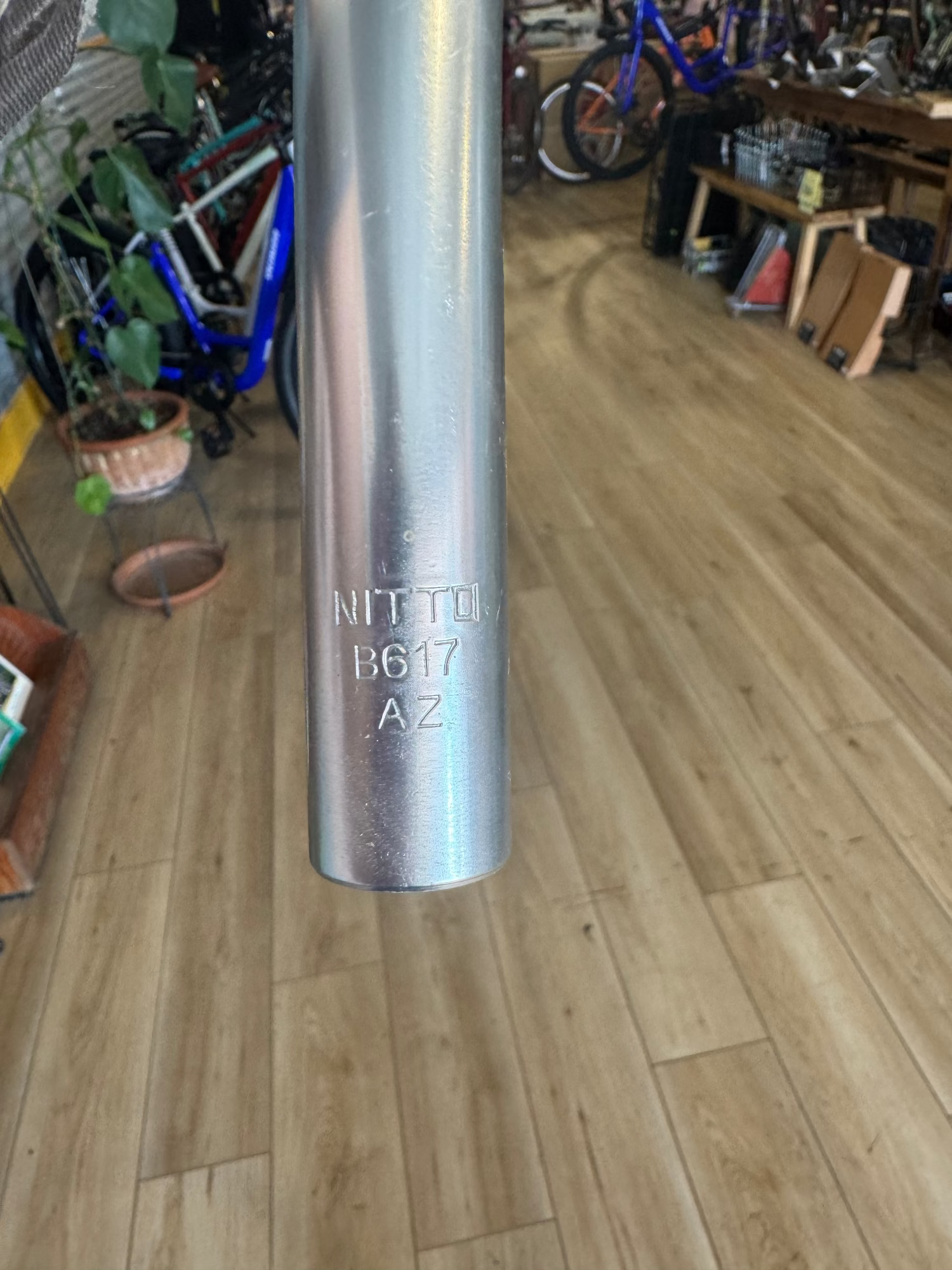 Close-up of Nitto B617 stamped logo on end of polished silver handlebar.