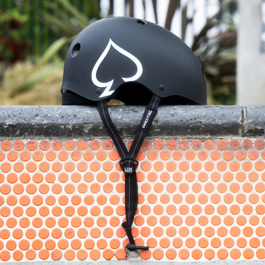 Black helmet with white logo on a textured orange surface