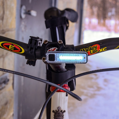 Close-up of a bicycle handlebar with a shiner 70 headlight attached.