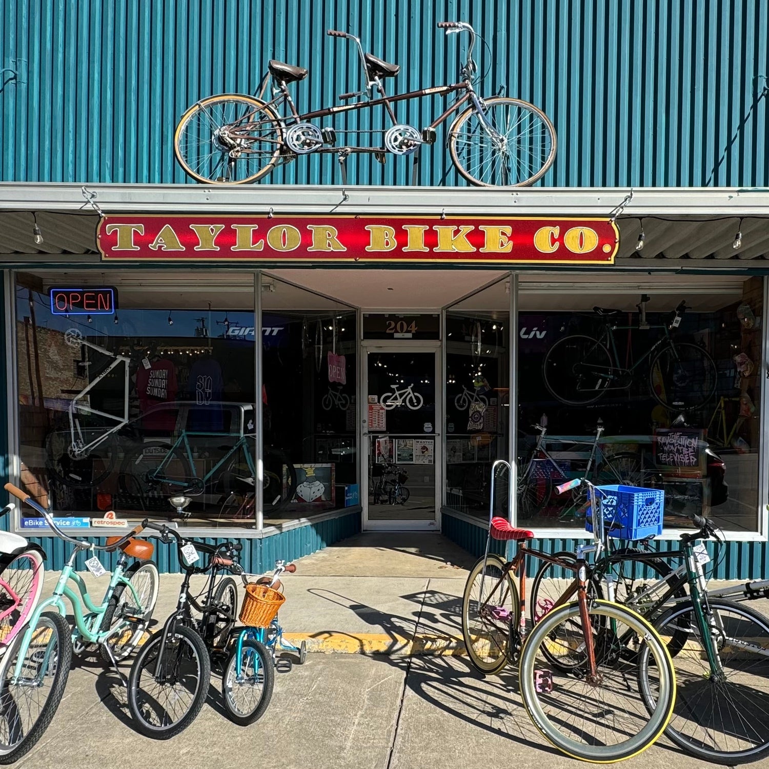Bicycles parked outside Taylor Bike Co. store with a blue building facade.